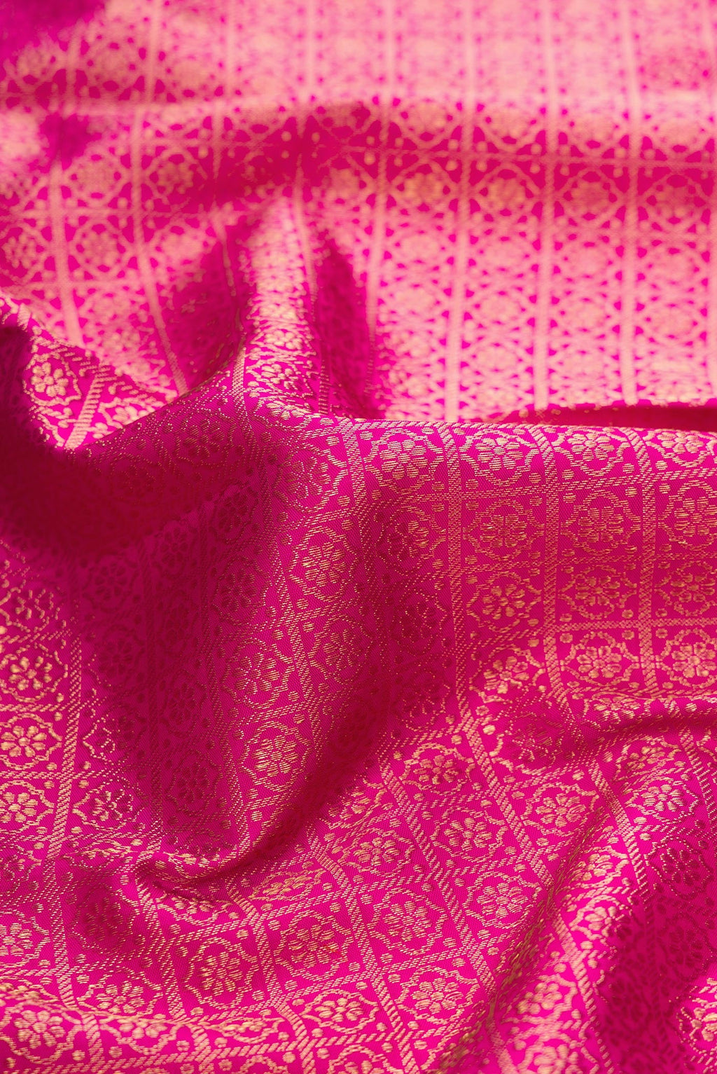 Close up of Dark Pink Dual Tone Kanjivaram Silk Saree with Zari Brocade on the body and Zari Border.  displaying folds