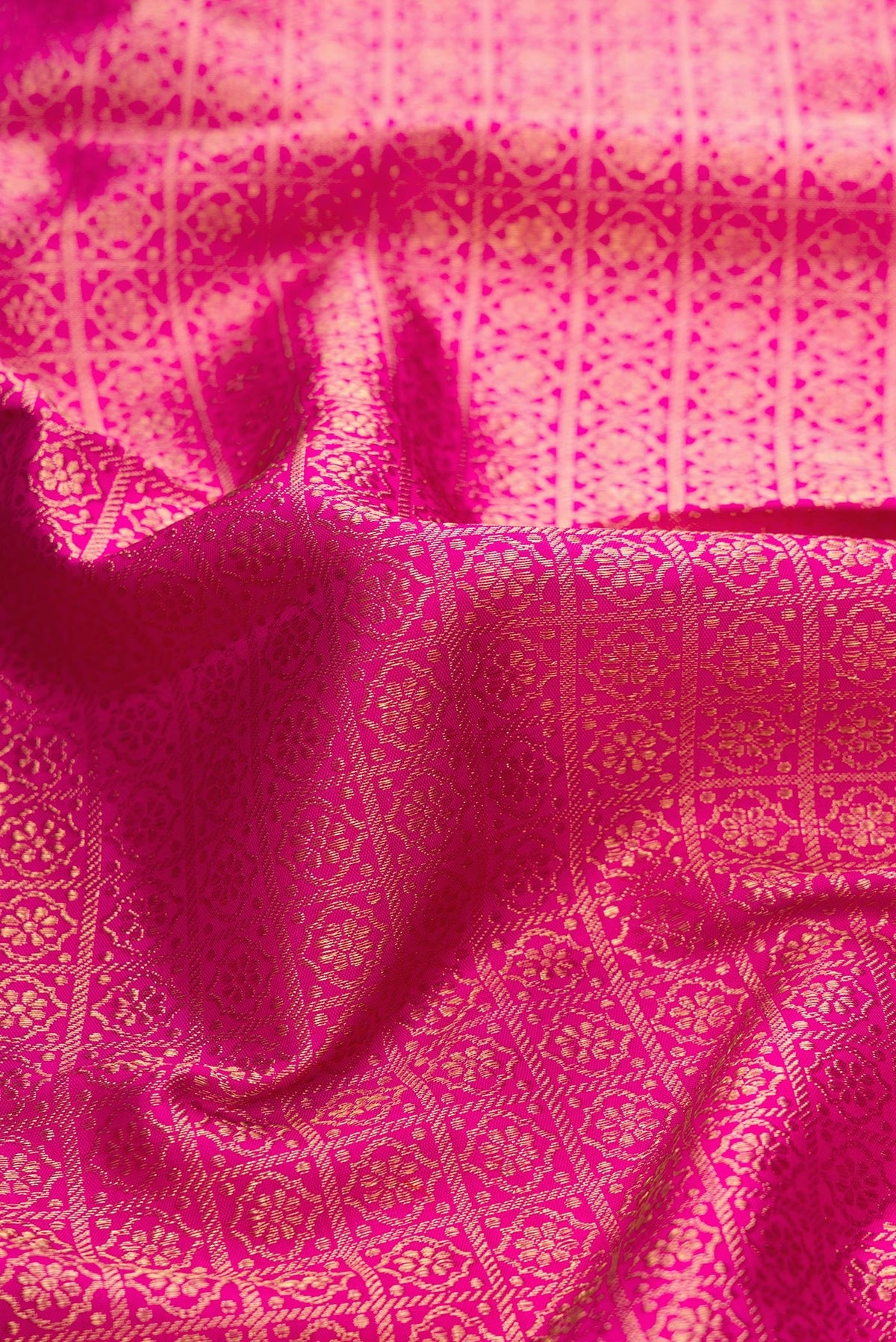 Close up of Dark Pink Dual Tone Kanjivaram Silk Saree with Zari Brocade on the body and Zari Border.  displaying folds