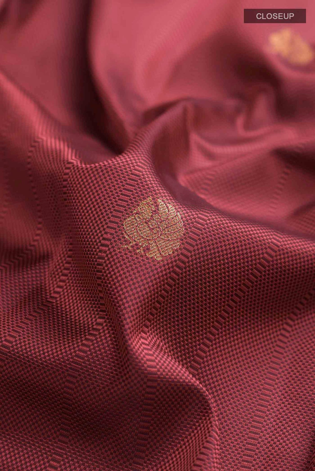 Close up of Maroon Kanchipuram Silk Saree with Jacquard With Zari Butta on the body and Zari Border displaying folds