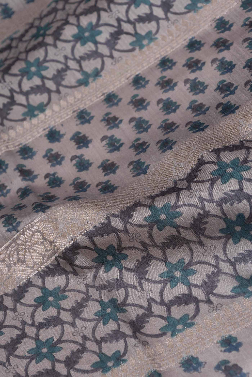 Close up of Grey Dual Tone Tussar Silk Saree with Printed design on the body and Embroidery Border displaying folds