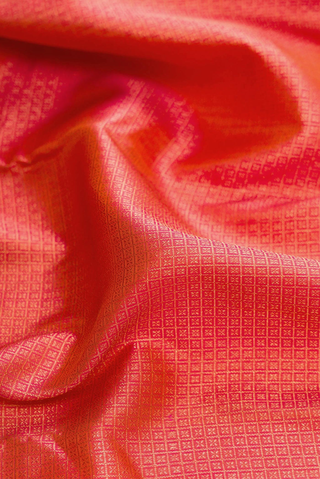 Close up of Brick Orange Dual Tone Kanjivaram Silk Saree with Zari Brocade on the body and Fancy Border.  displaying folds