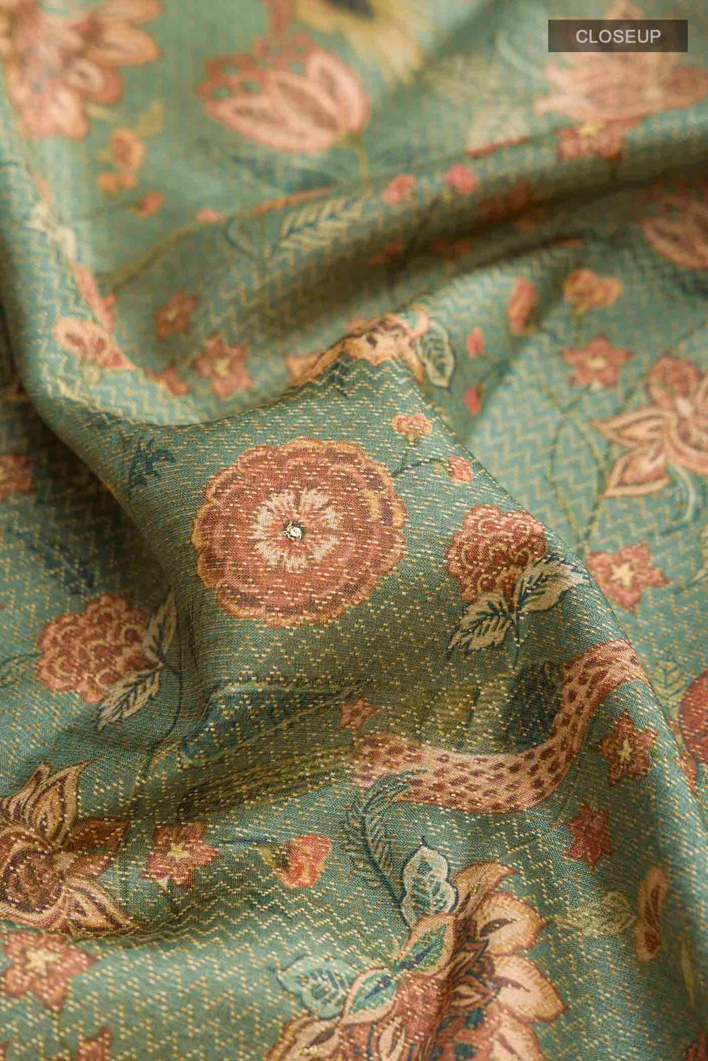Close up of Green Tussar Silk Saree with Printed design on the body and Zari Border displaying folds