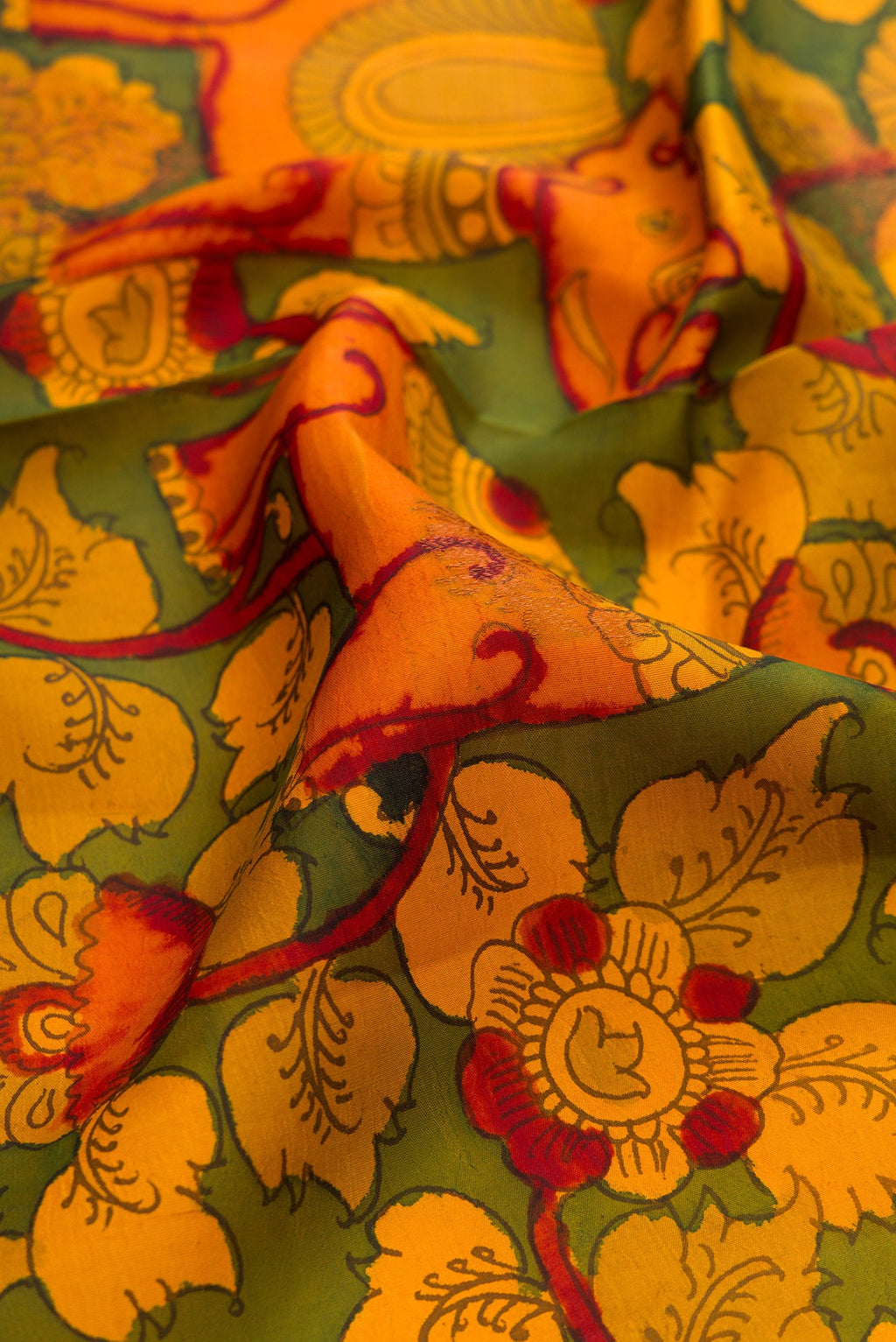 Close up of Green Dual Tone Kanchipuram Silk Saree with kalamkari Print on the body and Zari Border.  displaying folds