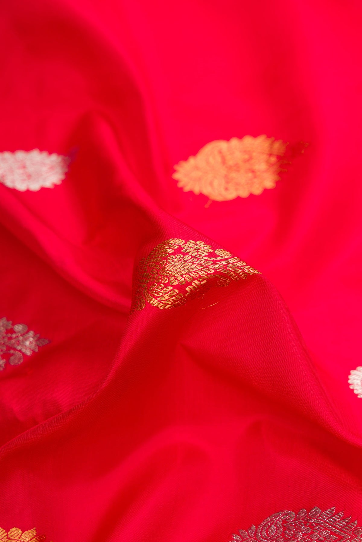 Close up of Red Dual Tone Gadwal Silk Saree with Zari Butta on the body and Zari Border.  displaying folds