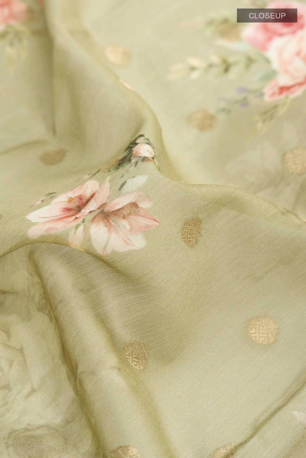 Close up of Green Silk Cotton Saree with Printed design on the body and Zari Border displaying folds