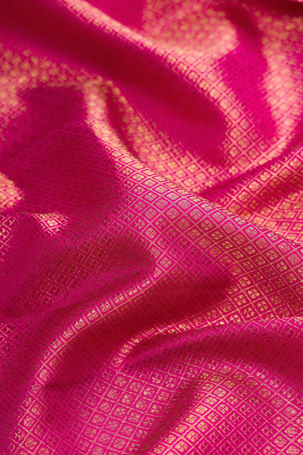 Close up of Pure Silk Pure Zari Magenta Dual Tone Kanjivaram Saree with Zari Brocade on the body and Zari Border.  displaying folds