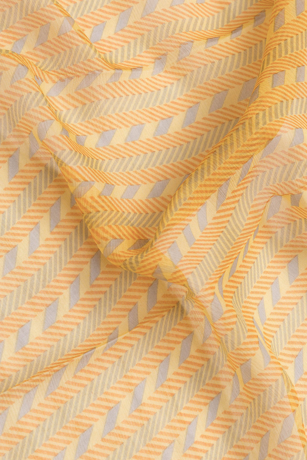 Close up of Yellow Dual Tone Mysore Georgette Saree with Printed design on the body and Zari Border.  displaying folds