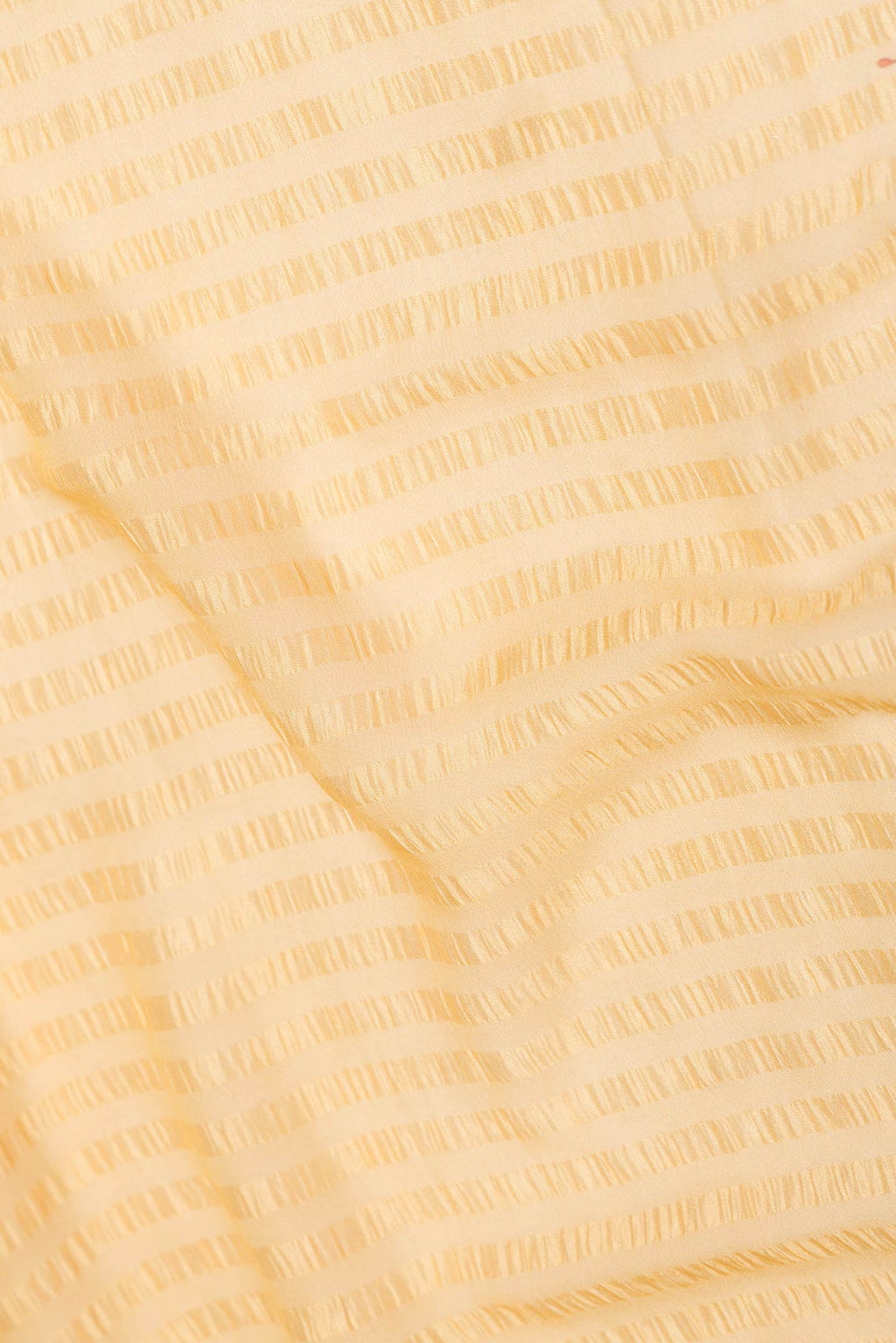 Close up of Yellow Dual Tone Mysore Chiffon Saree with Printed design on the body and Zari Border displaying folds