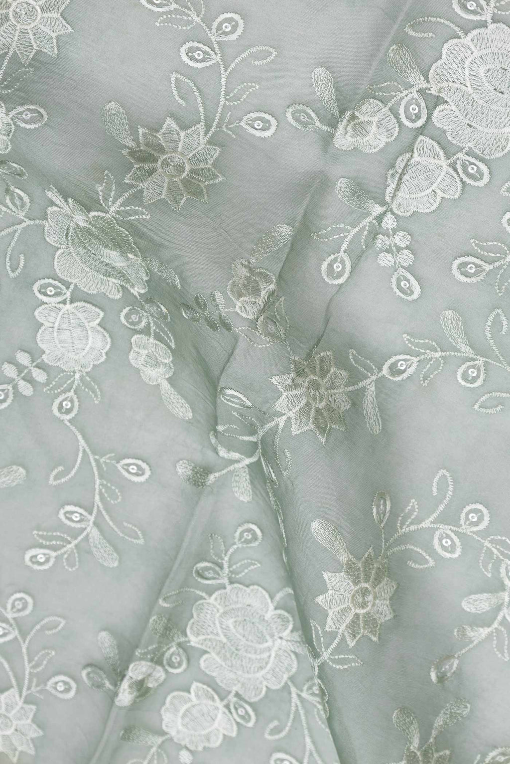 Close up of Light Green Dual Tone Organza Silk Saree with Zari Brocade on the body and Zari Border.  displaying folds