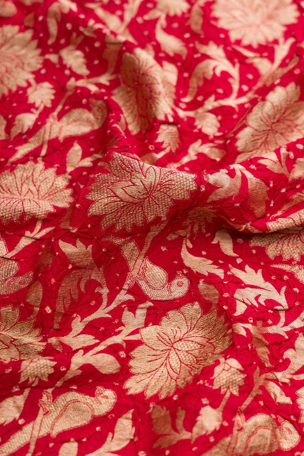 Close up of Red Dual Tone Bandhani Silk Saree with Bandhani Print on the body and Without Border.  displaying folds