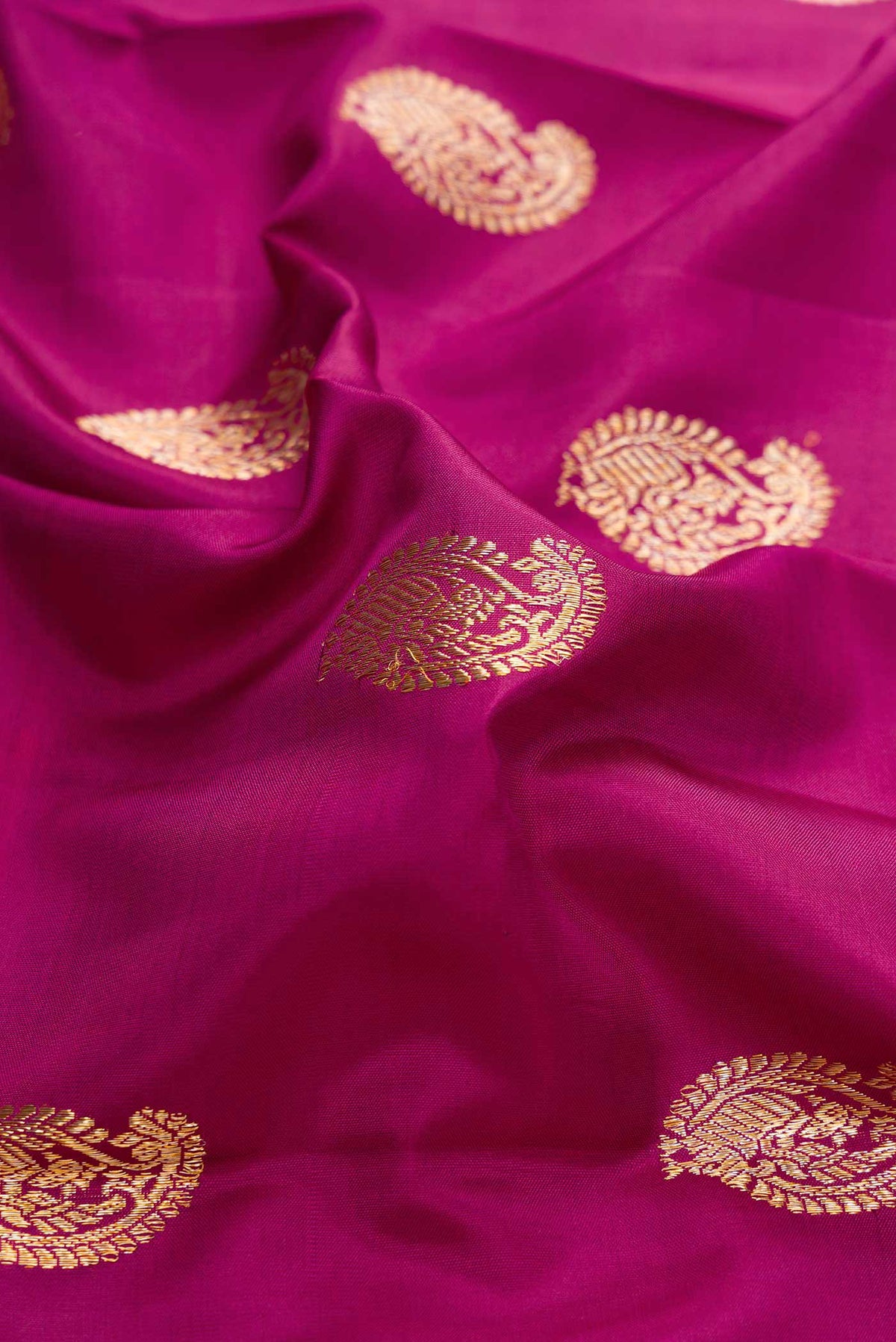 Close up of Magenta Dual Tone Kanchipuram Silk Saree with Zari Butta on the body and Fancy Border displaying folds