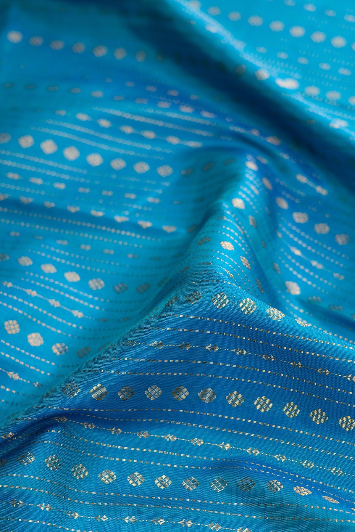 Close up of Peacock Blue Dual Tone Kanchipuram Silk Saree with Stripes on the body and Zari Border.  displaying folds