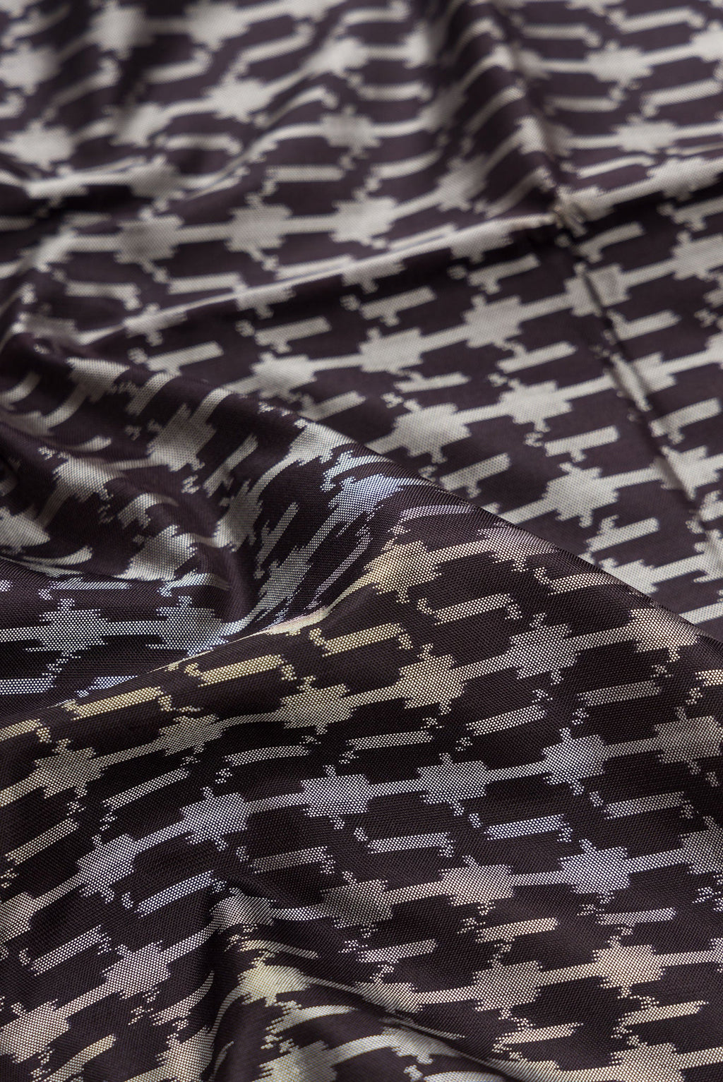 Close up of Black Dual Tone Double Ikat Saree with Ikat Print on the body and Zari Border.  displaying folds