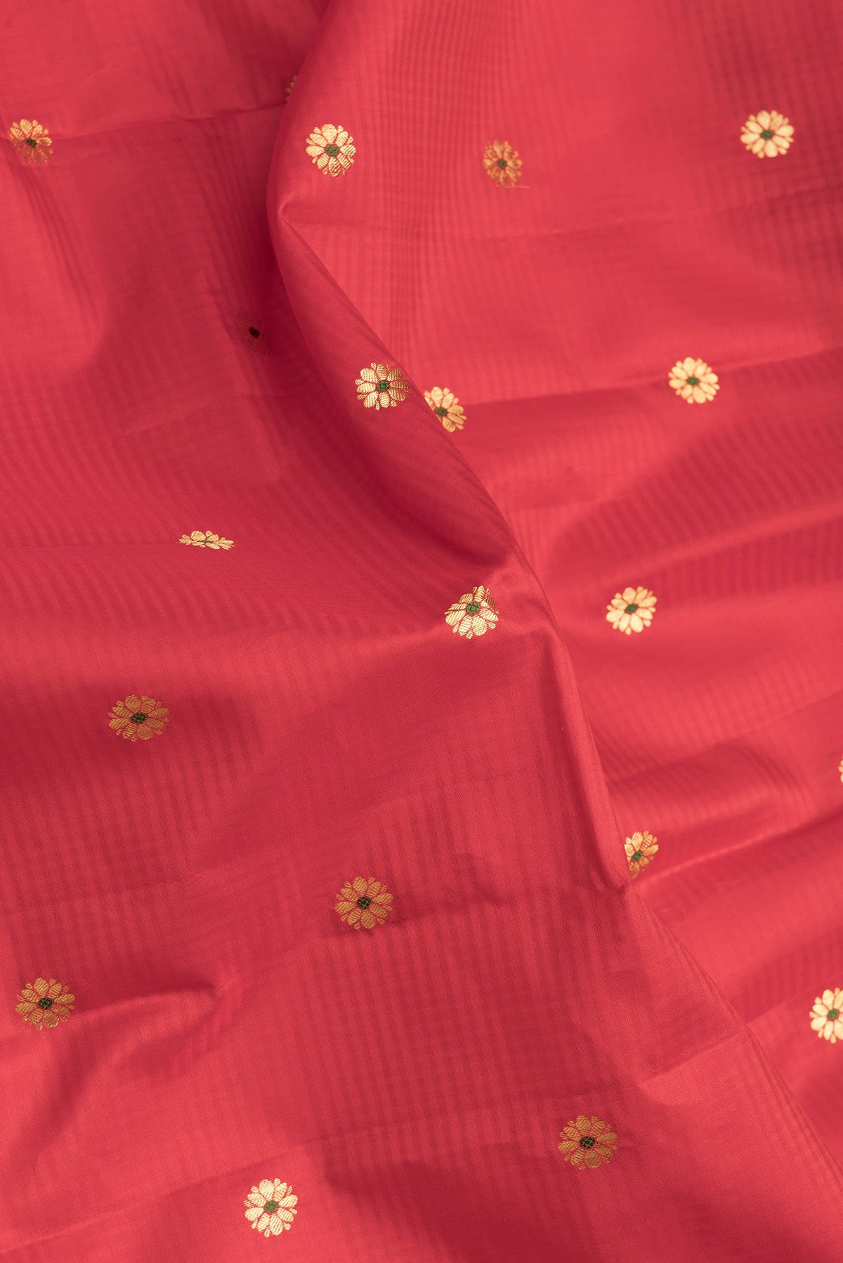 Close up of Red Dual Tone Kanchipuram Silk Saree with Zari And Thread Butta on the body and Zari Border.  displaying folds