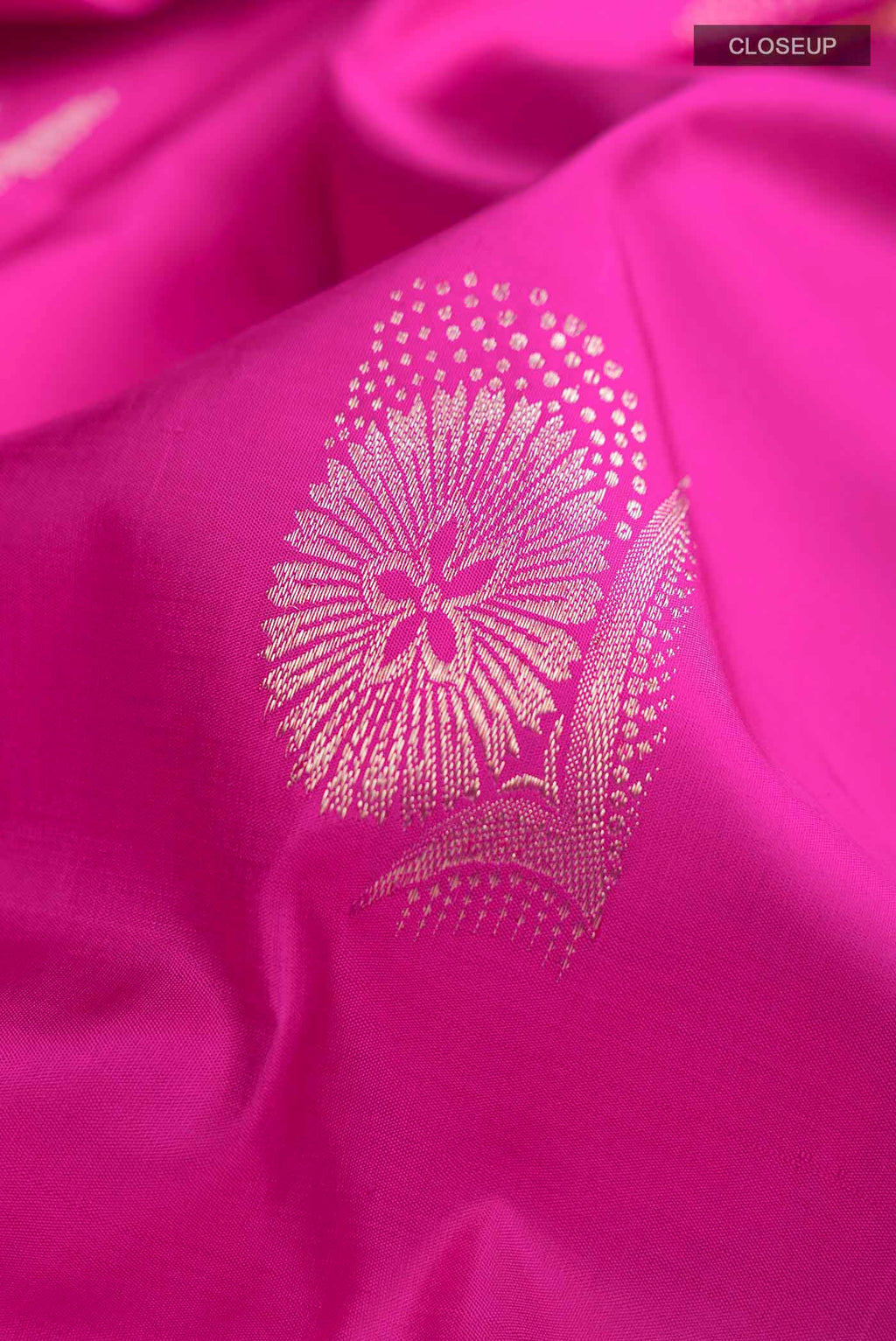Close up of Pink Kanchipuram Silk Saree with Zari Butta on the body and Zari Border displaying folds
