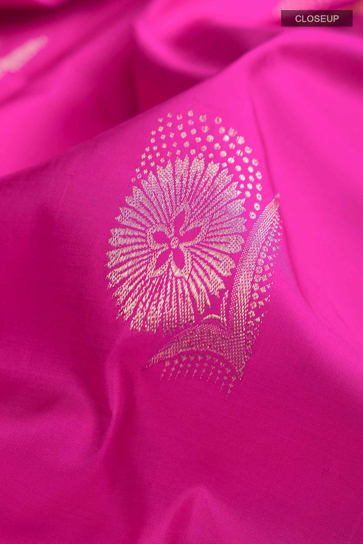Close up of Pink Kanchipuram Silk Saree with Zari Butta on the body and Zari Border displaying folds