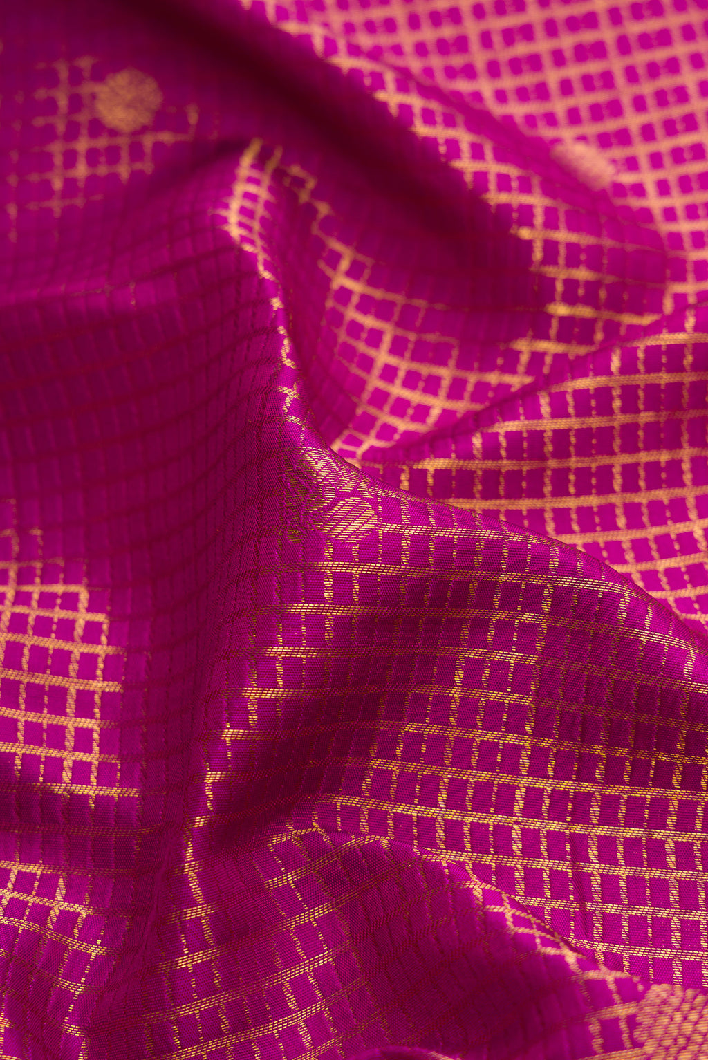 Close up of Magenta Kanjivaram Silk Saree with Zari Brocade on the body and Zari Border.  displaying folds