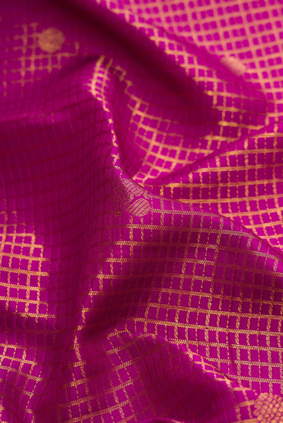 Close up of Magenta Kanjivaram Silk Saree with Zari Brocade on the body and Zari Border.  displaying folds
