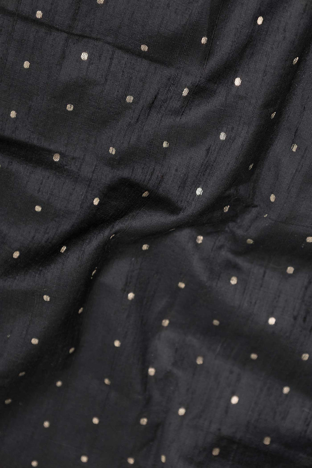 Close up of Black Dual Tone Raw Silk Saree with Zari Butta on the body and Zari Border displaying folds