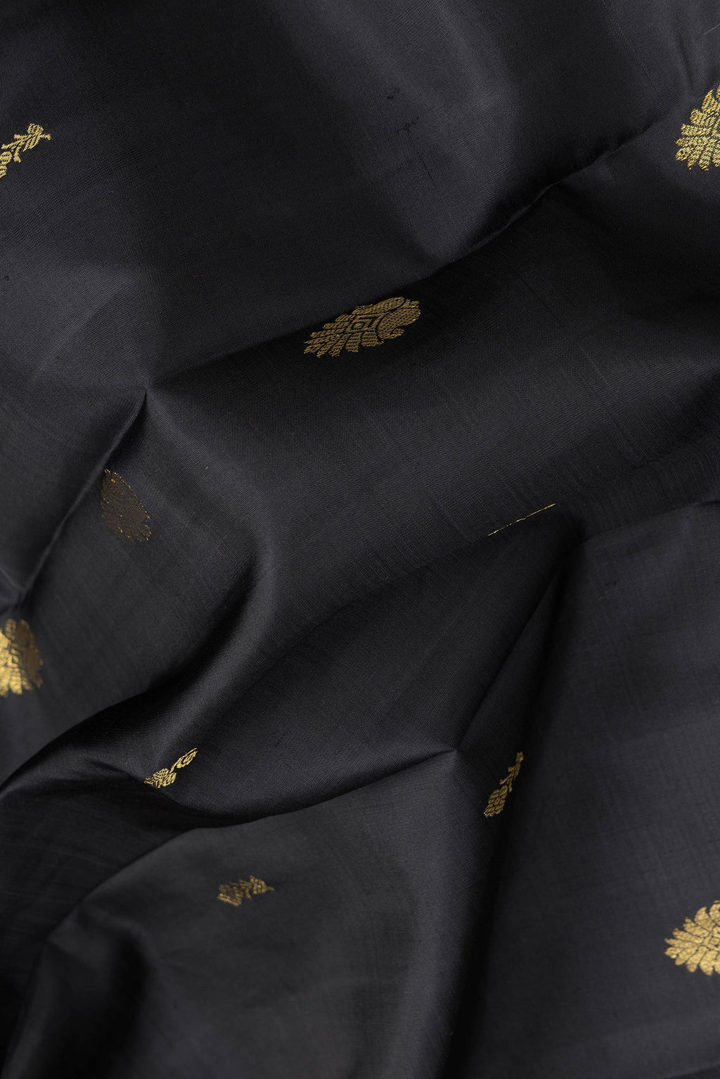 Close up of Black Dual Tone Kanjivaram Silk Saree with Zari Butta on the body and Zari Border.  displaying folds