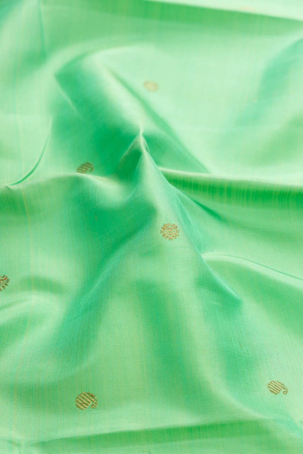 Close up of Sea Green Dual Tone Kanchipuram Silk Saree with Zari Butta on the body and Zari Border displaying folds