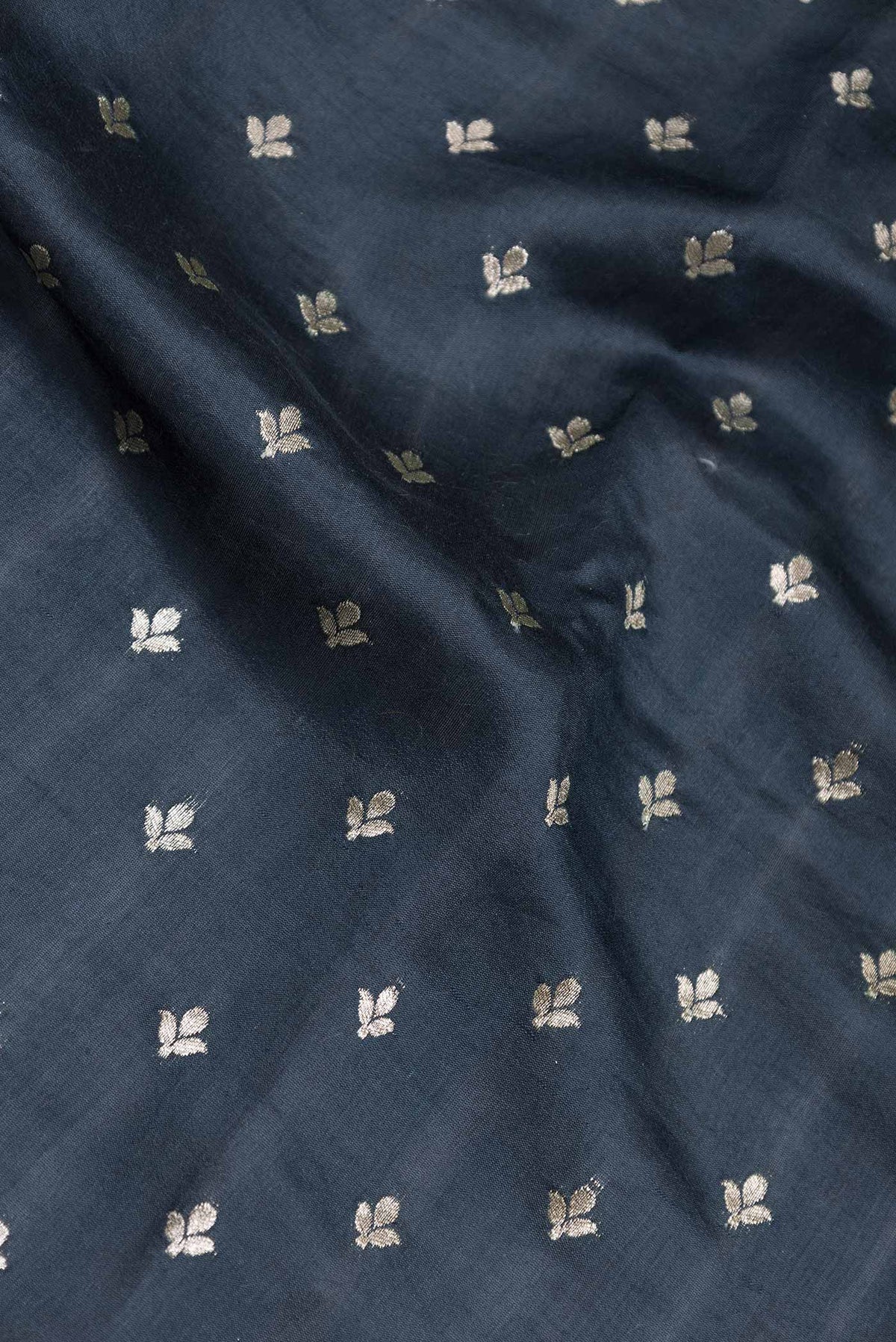 Close up of Black Tussar Silk Saree with Zari Butta on the body and Without Border displaying folds