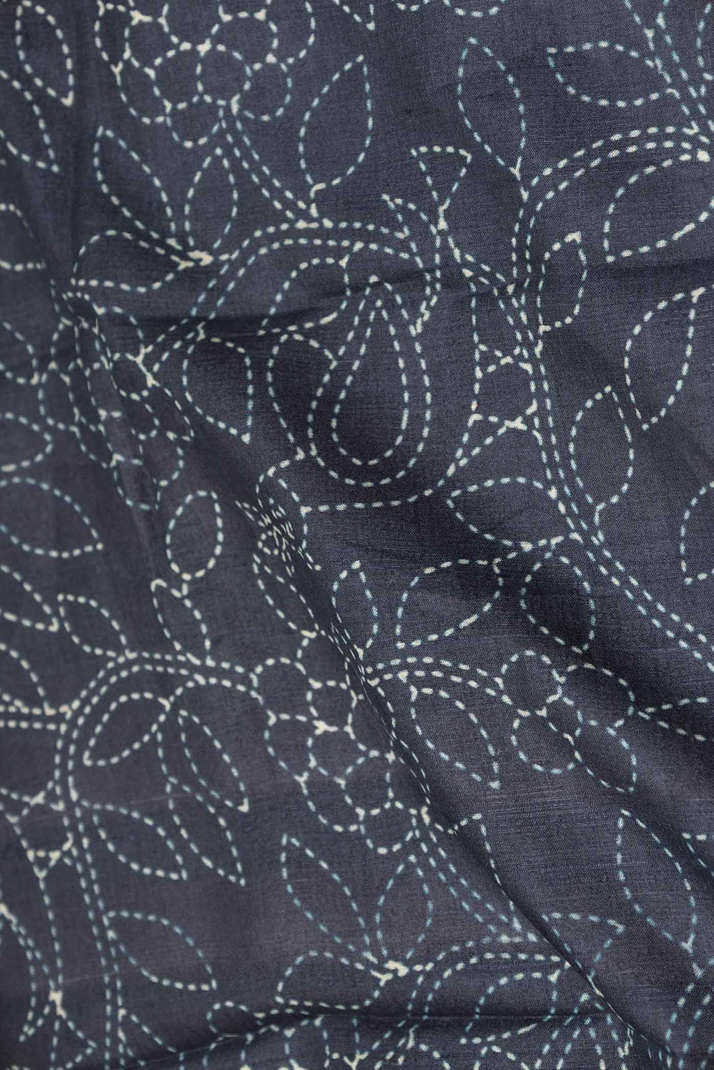 Close up of Black Dual Tone Tussar Silk Saree with Printed design on the body and Zari Border displaying folds