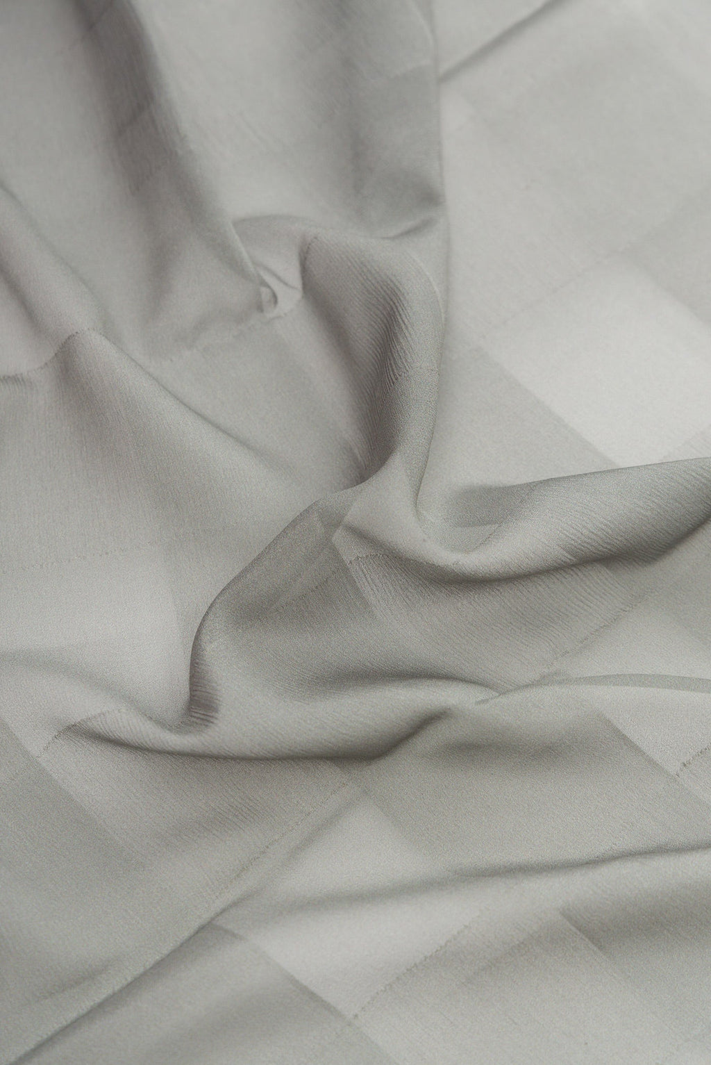 Close up of Grey Dual Tone Mysore Crepe Saree with Printed design on the body and Fancy Border.  displaying folds
