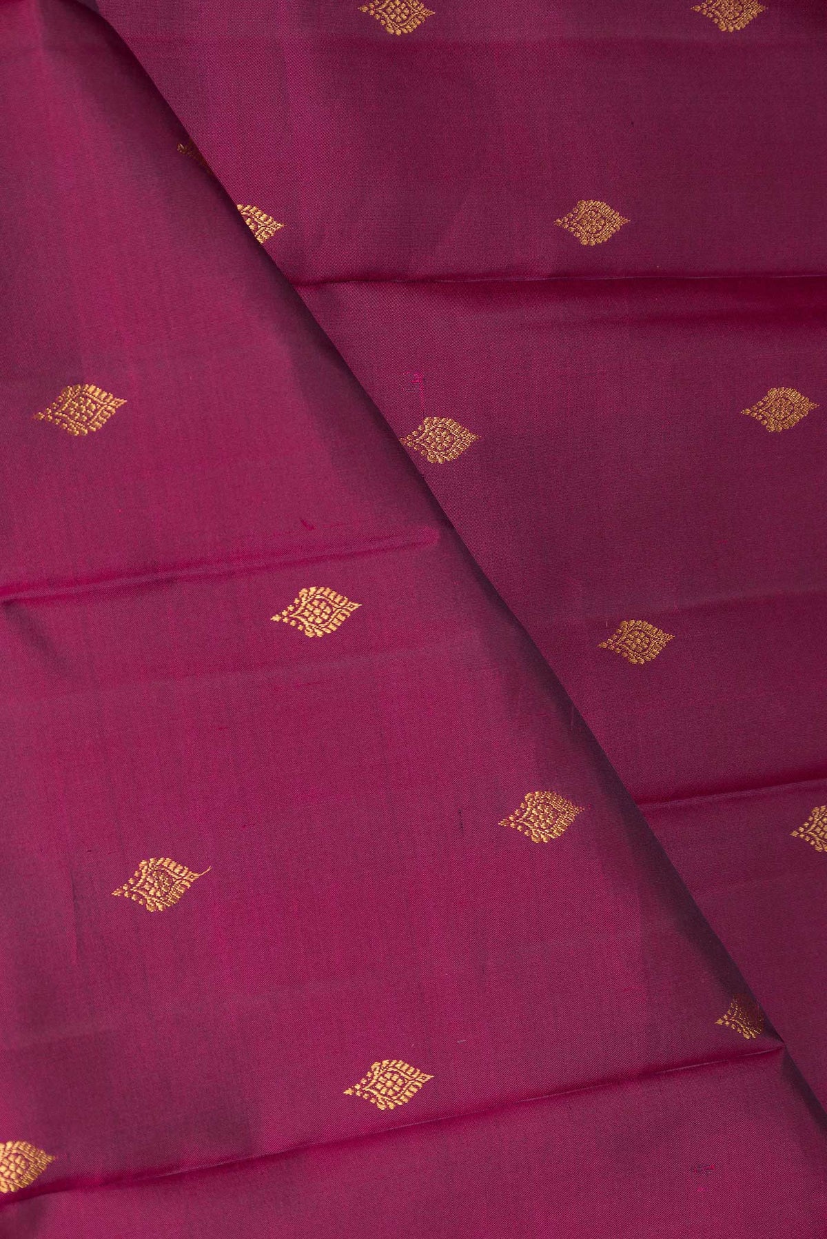 Close up of Magenta Dual Tone Kanchipuram Saree with Zari Butta on the body and Zari Border displaying folds