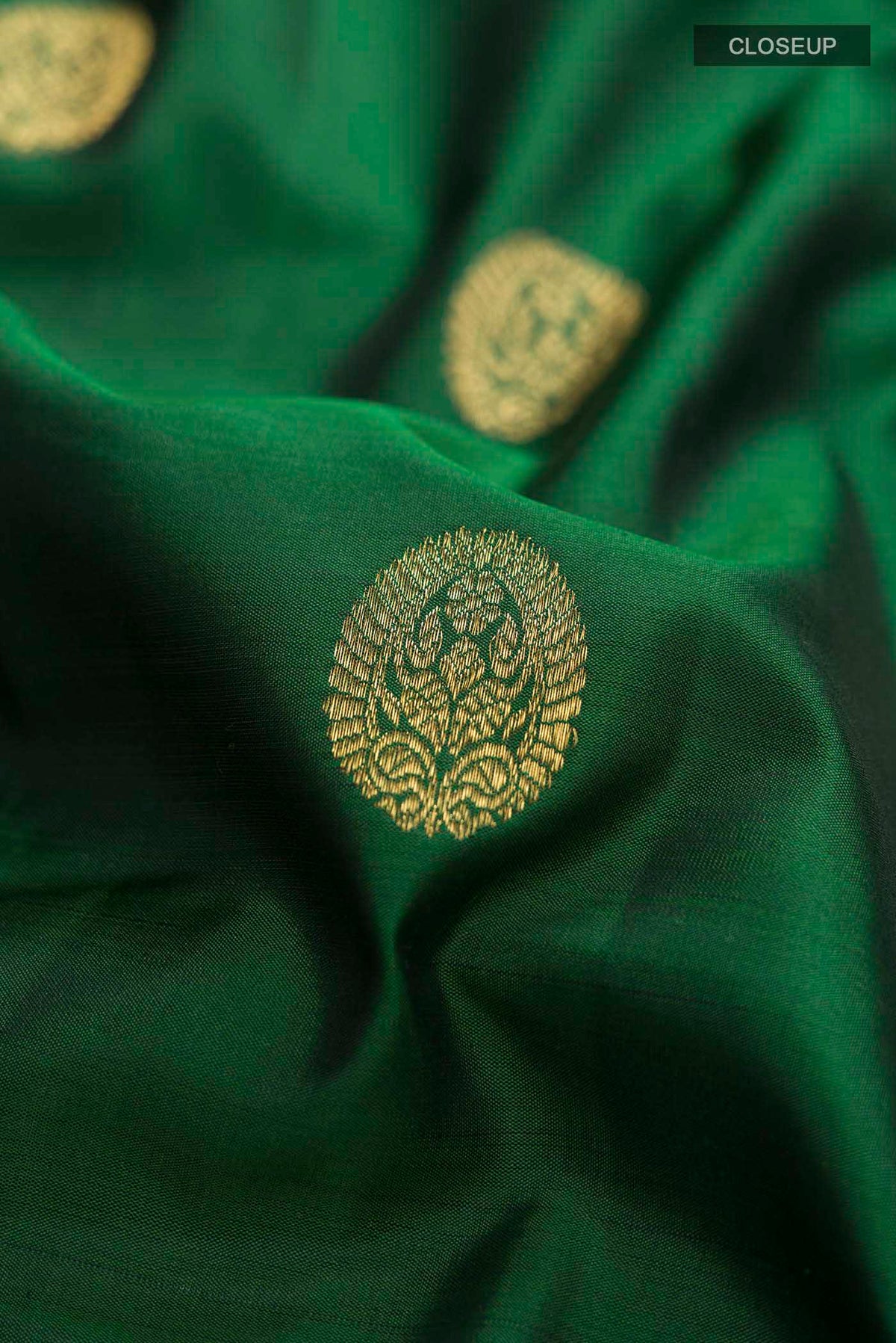 Close up of Green Kanchipuram Silk Saree with Zari Butta on the body and Zari Border displaying folds