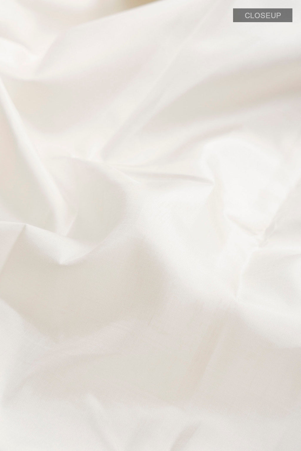 Close up of White Kanchipuram Silk Saree with Plain Body and Plain Border displaying folds