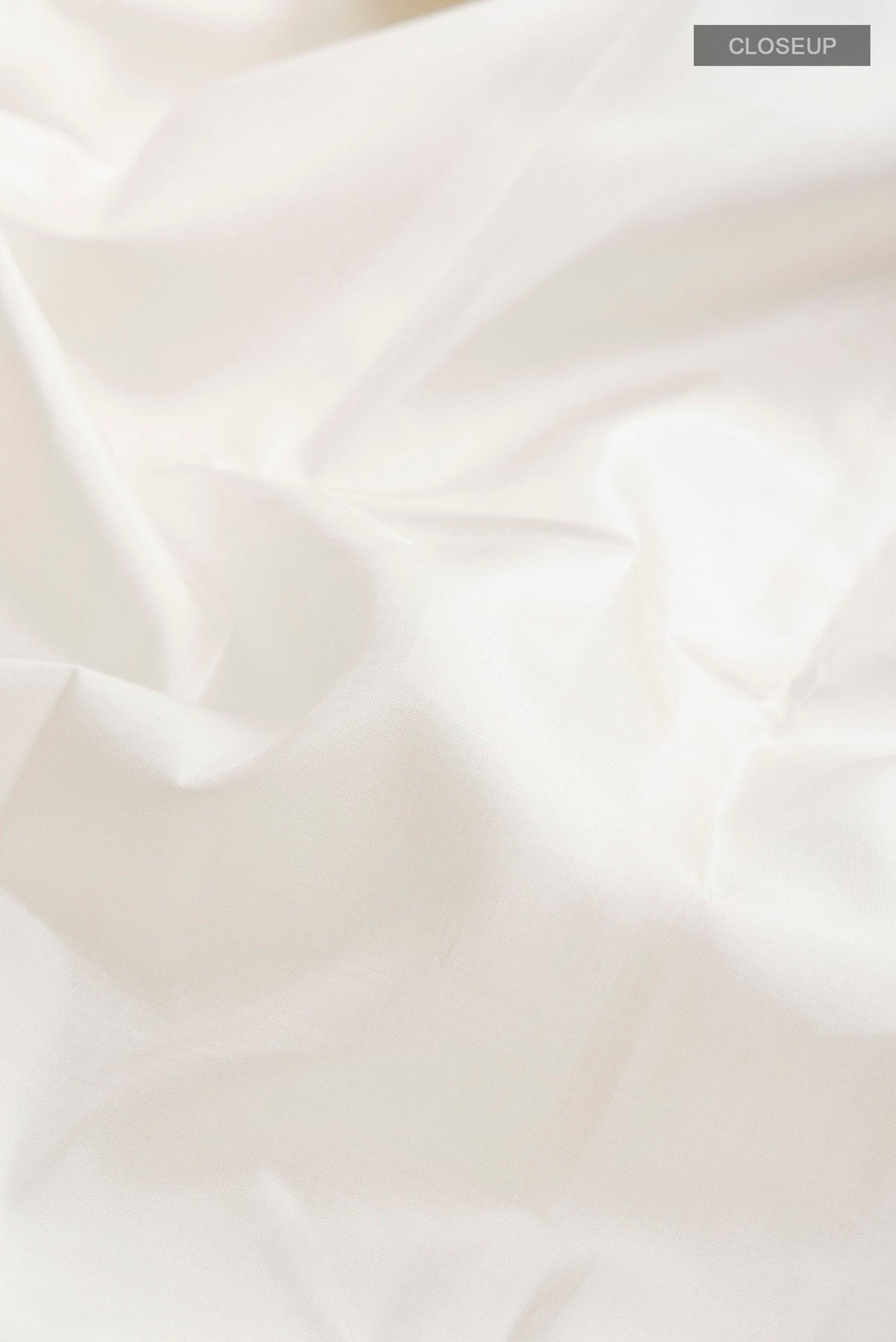 Close up of White Kanchipuram Silk Saree with Plain Body and Plain Border displaying folds