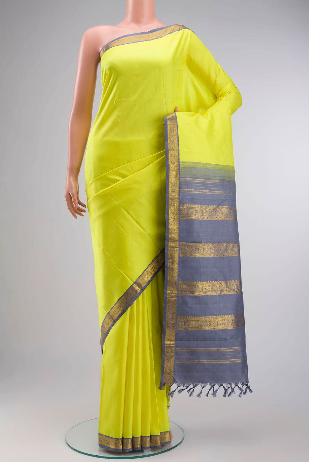 Yellow Kanchipuram Silk Saree with Plain Body and Zari Border displayed on a mannequin
