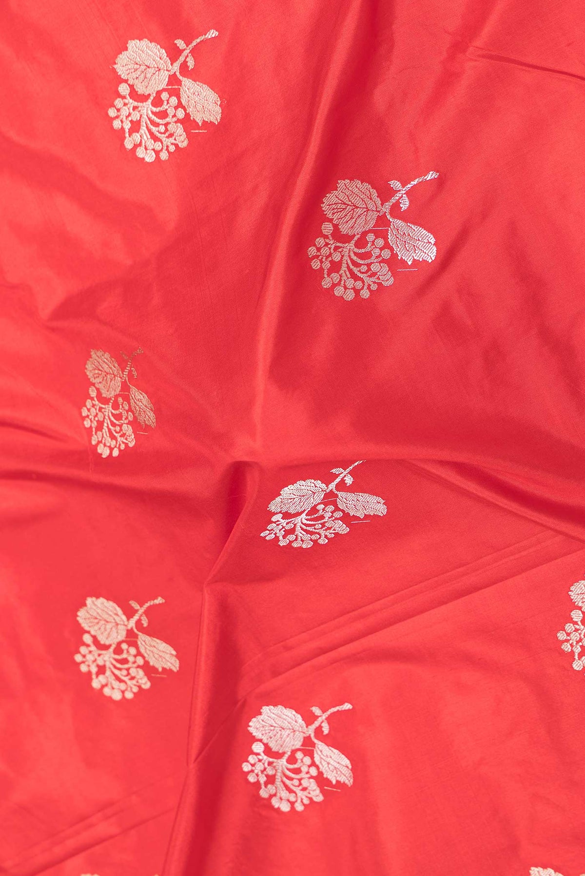 Close up of Red Dual Tone Banarasi Silk Saree with Zari Butta on the body and Plain Border displaying folds