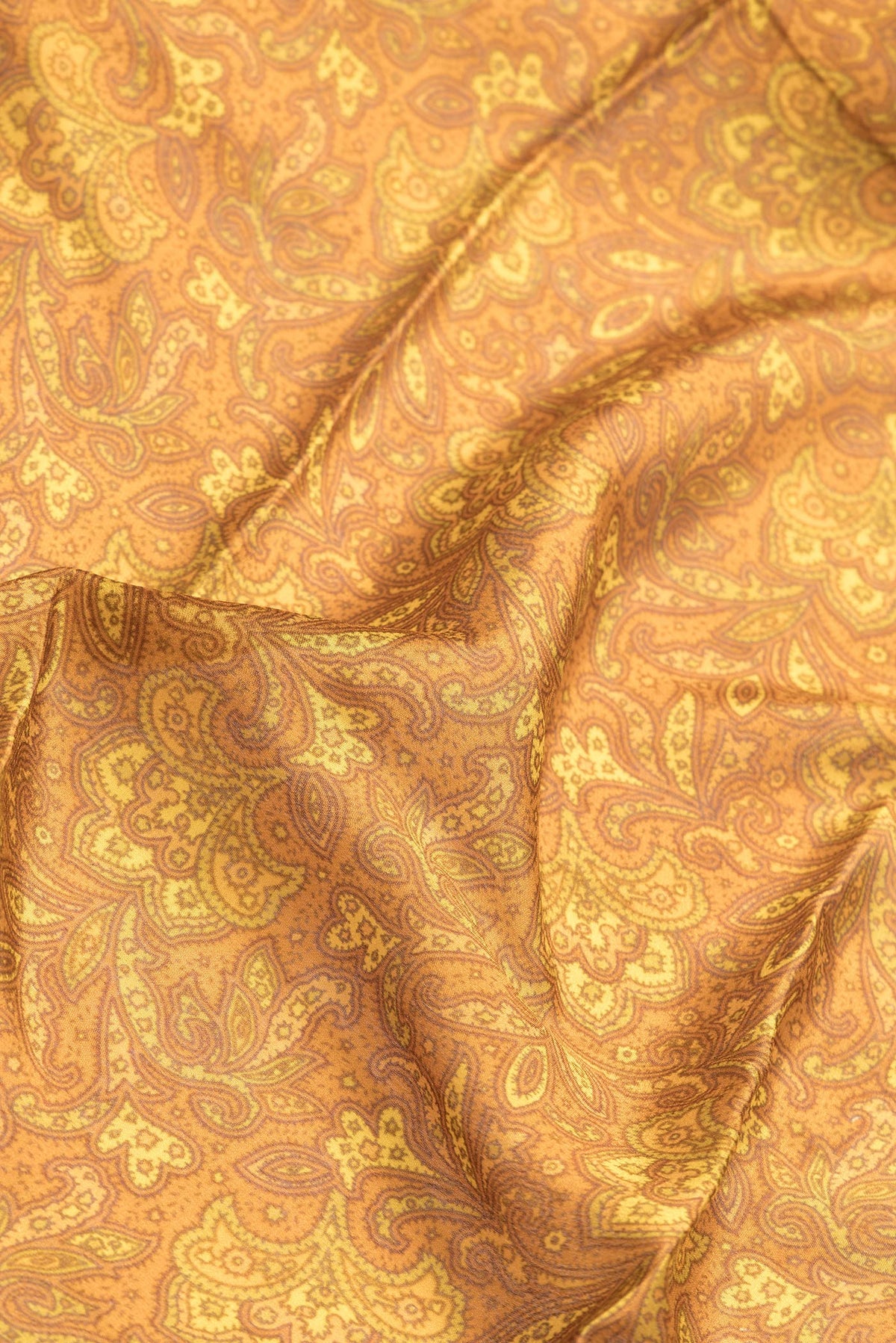 Close up of Mustard Dual Tone Mysore Crepe Saree with Printed design on the body and Zari Border.  displaying folds