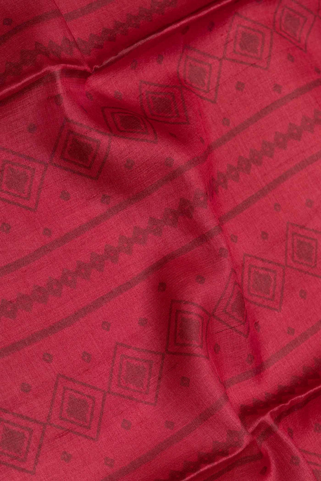 Close up of Red Dual Tone Tussar Saree with Printed design on the body and Printed Border displaying folds