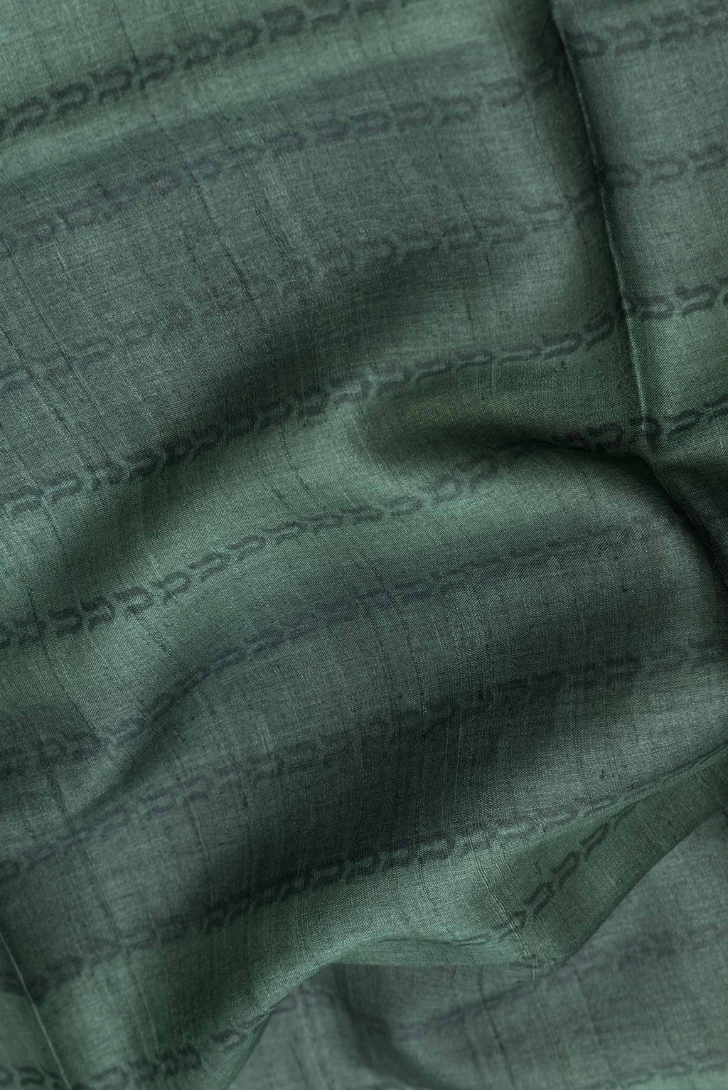 Close up of Green Dual Tone Tussar Silk SareePrinted design on the body and Plain Border displaying folds