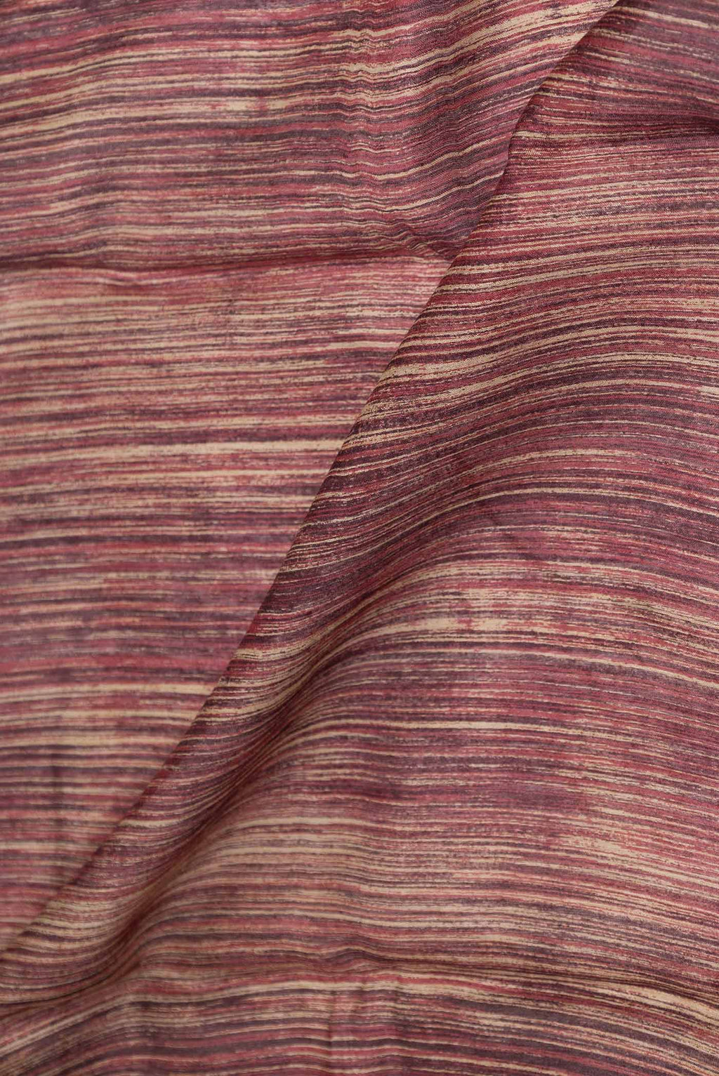 Close up of Maroon Dual Tone Tussar Saree with Printed design on the body and Printed Border displaying folds