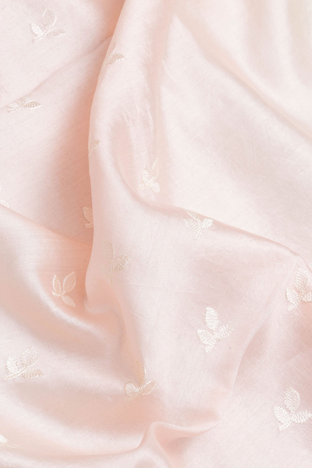 Close up of Rose Gold Dual Tone Tussar Silk Saree with Embroidery on the body and Zari Border.  displaying folds
