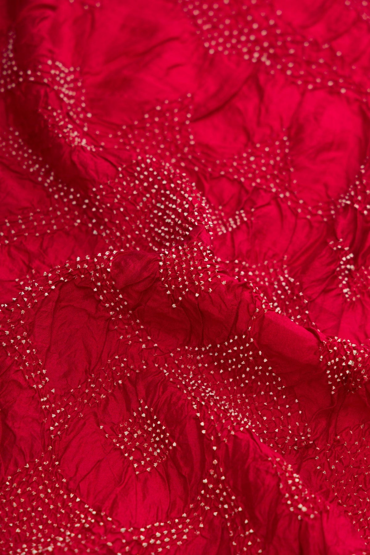 Close up of Maroon Dual Tone Bandhani Silk Saree with Bandhani Print on the body and Printed Border.  displaying folds