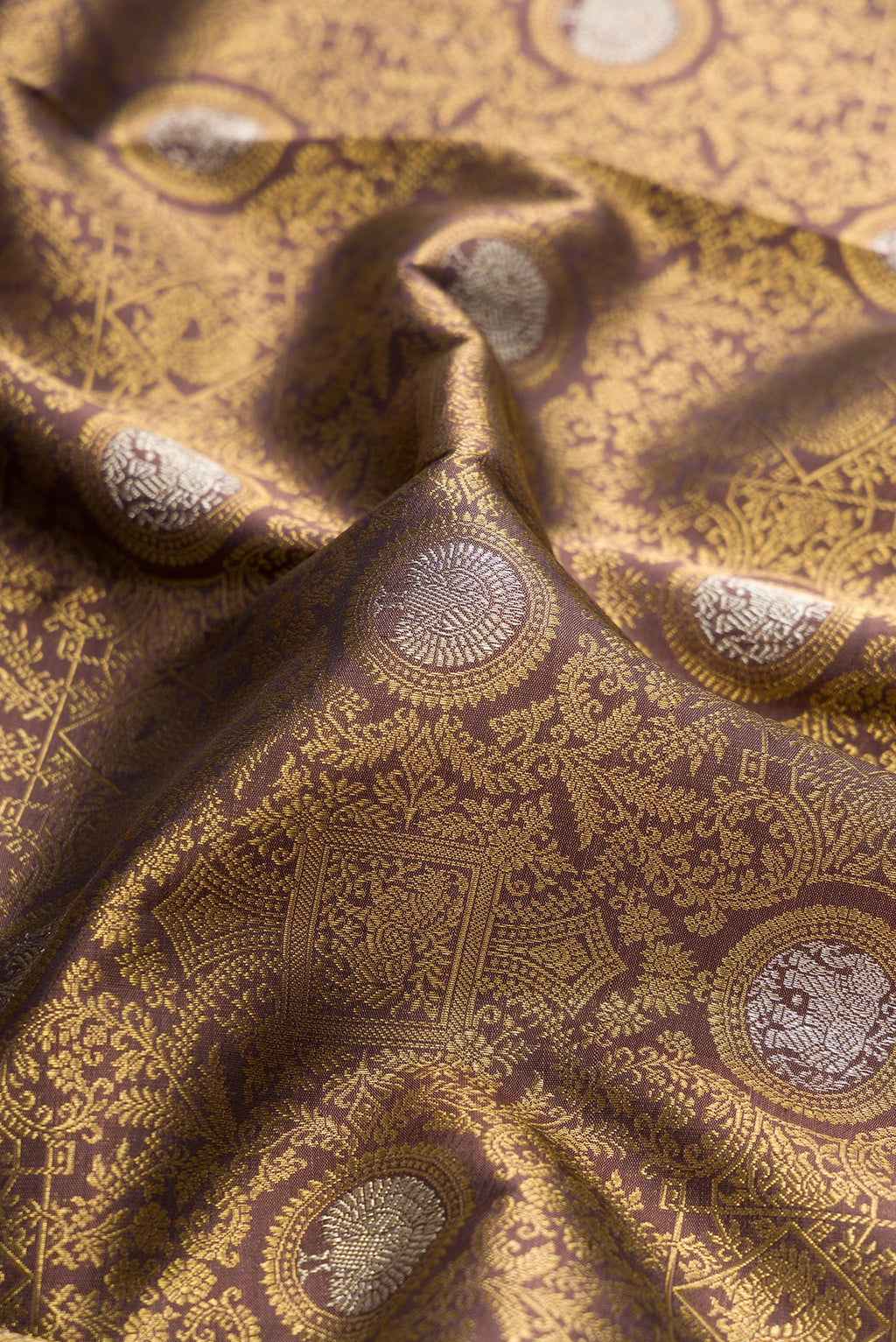Close up of Pure Silk Pure Zari Brown Dual Tone Kanjivaram Saree with Zari Brocade on the body and Zari Border.  displaying folds