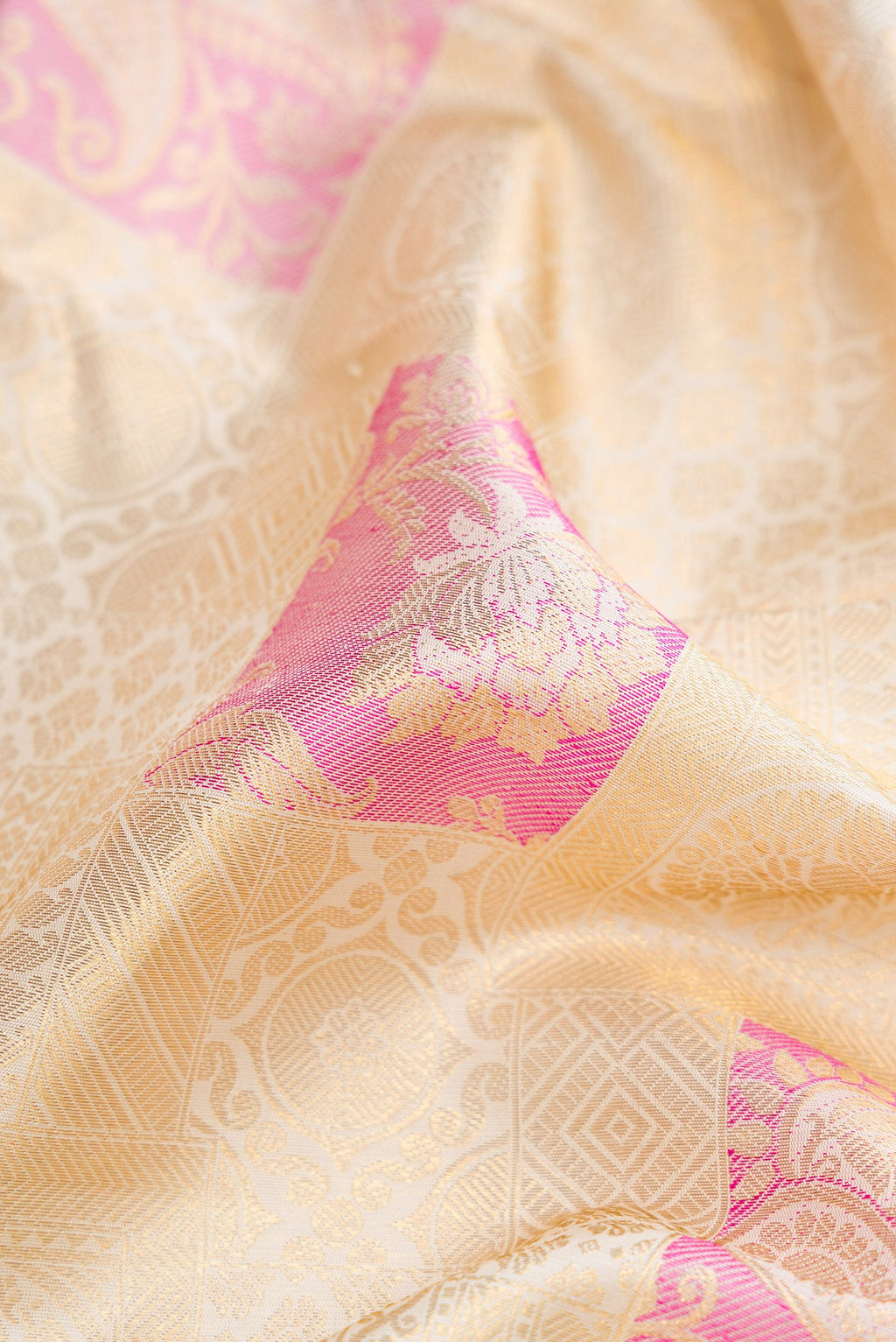 Close up of Off White Dual Tone Kanchipuram Silk Saree with Zari Brocade on the body and Zari Border.  displaying folds