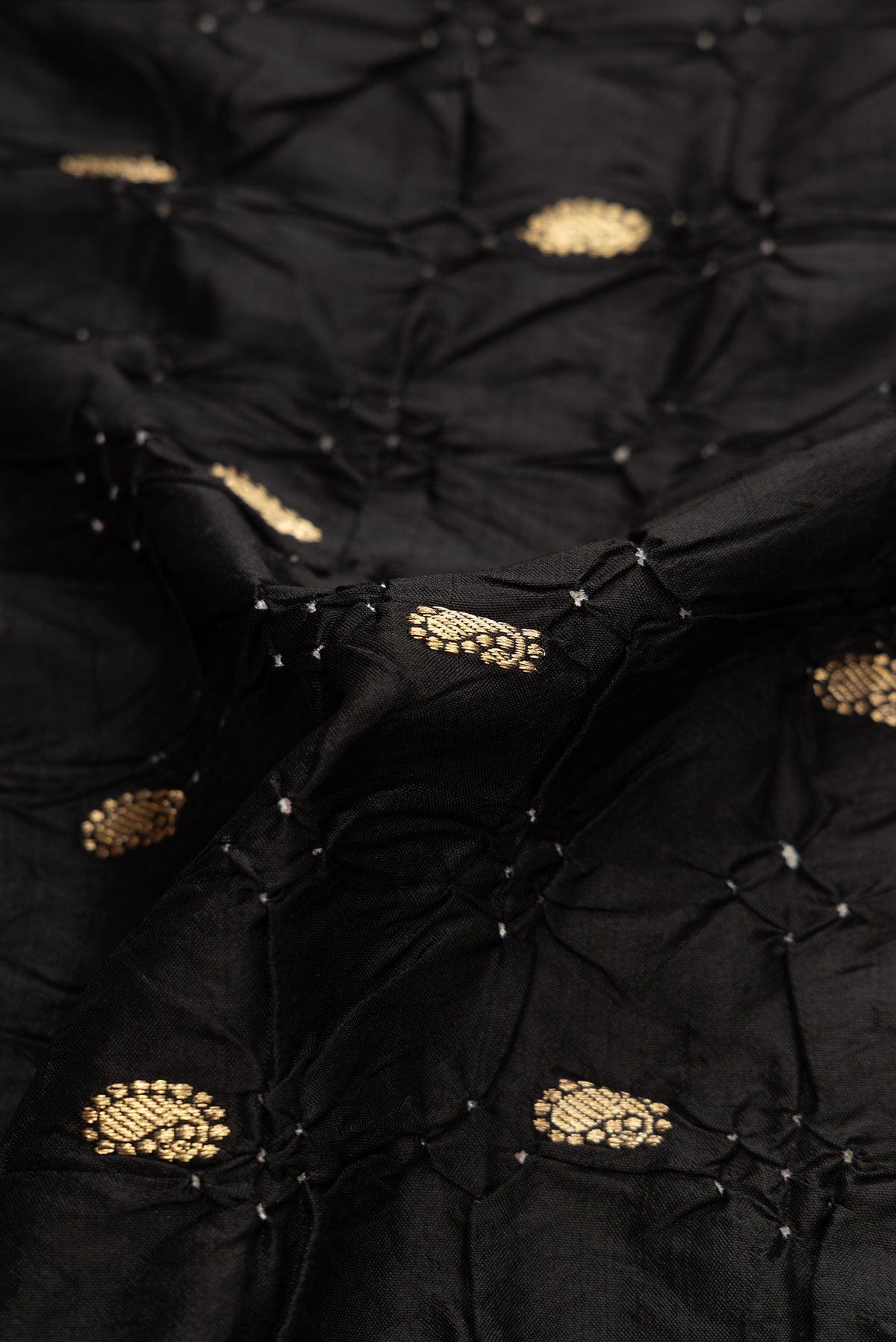 Close up of Black Dual Tone Bandhani Silk Saree with Bandhani Print on the body and Zari Border.  displaying folds