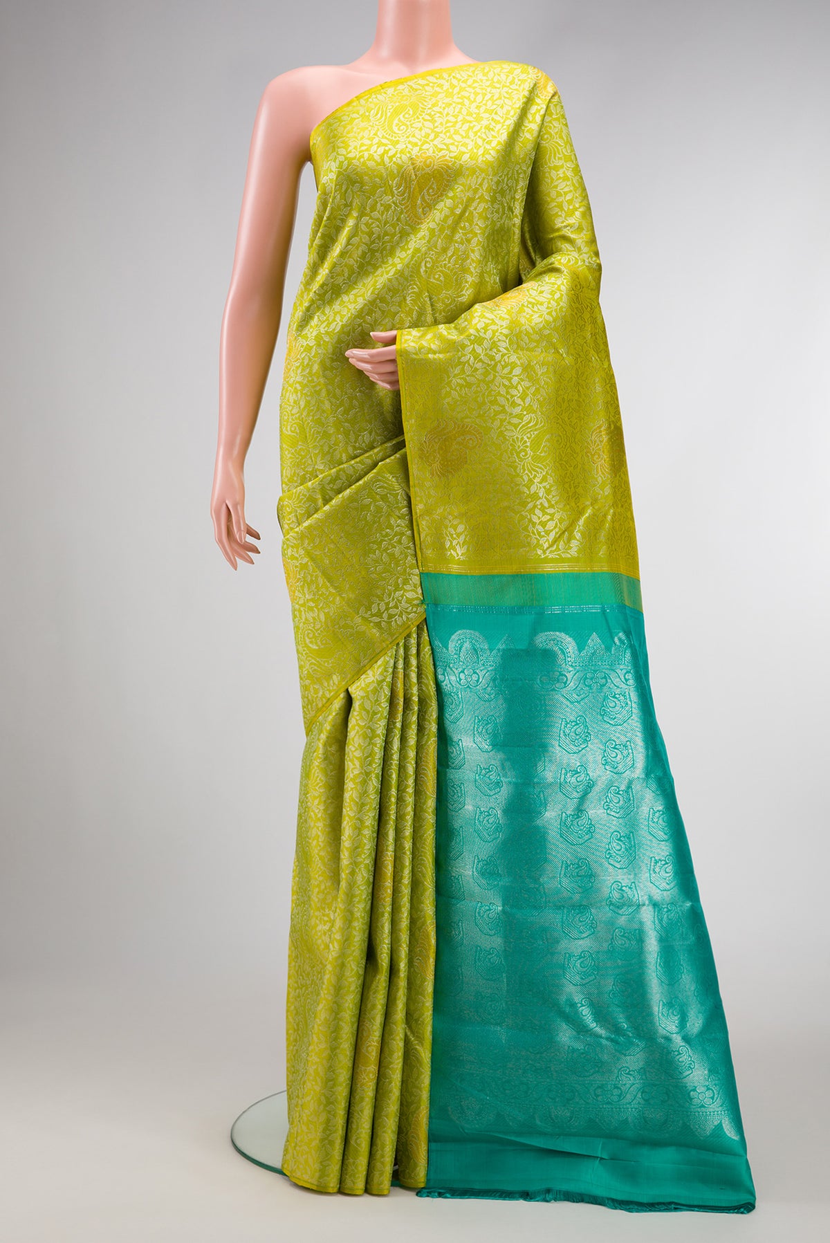 Parrot Green Kanjivaram Silk Saree with Zari Brocade on the body and Without Border.  displayed on a mannequin