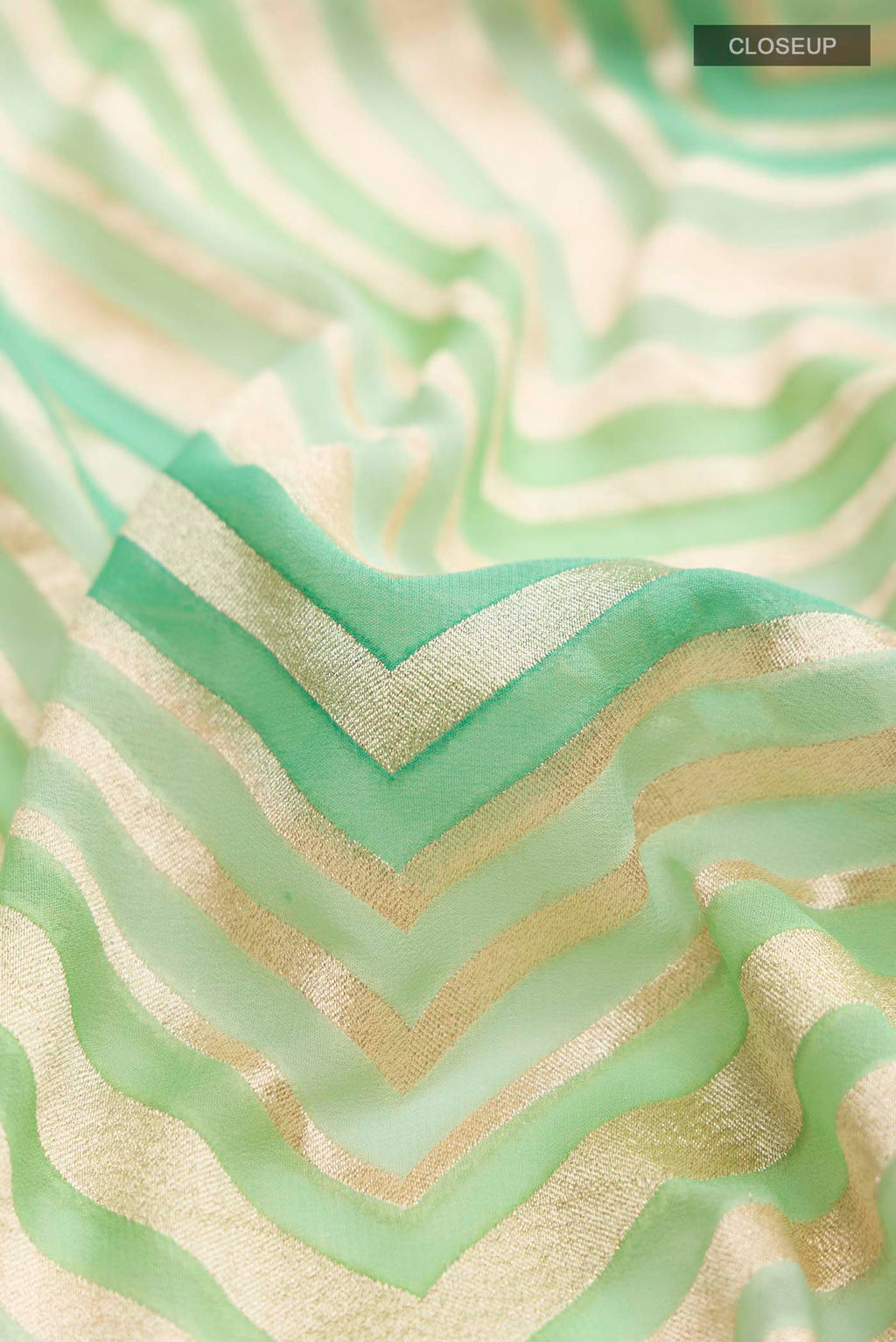 Close up of Green Banarasi Georgette Saree with Zari Butta on the body and Zari Border displaying folds