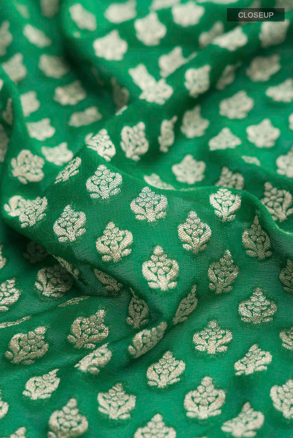 Close up of Green Banarasi Georgette Saree with Zari Butta on the body and Zari Border displaying folds