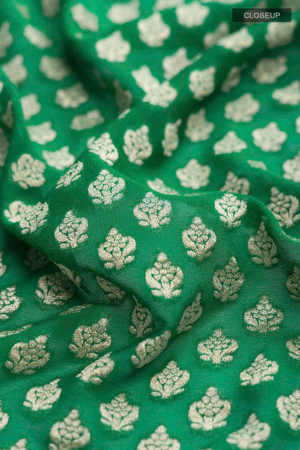 Close up of Green Banarasi Georgette Saree with Zari Butta on the body and Zari Border displaying folds