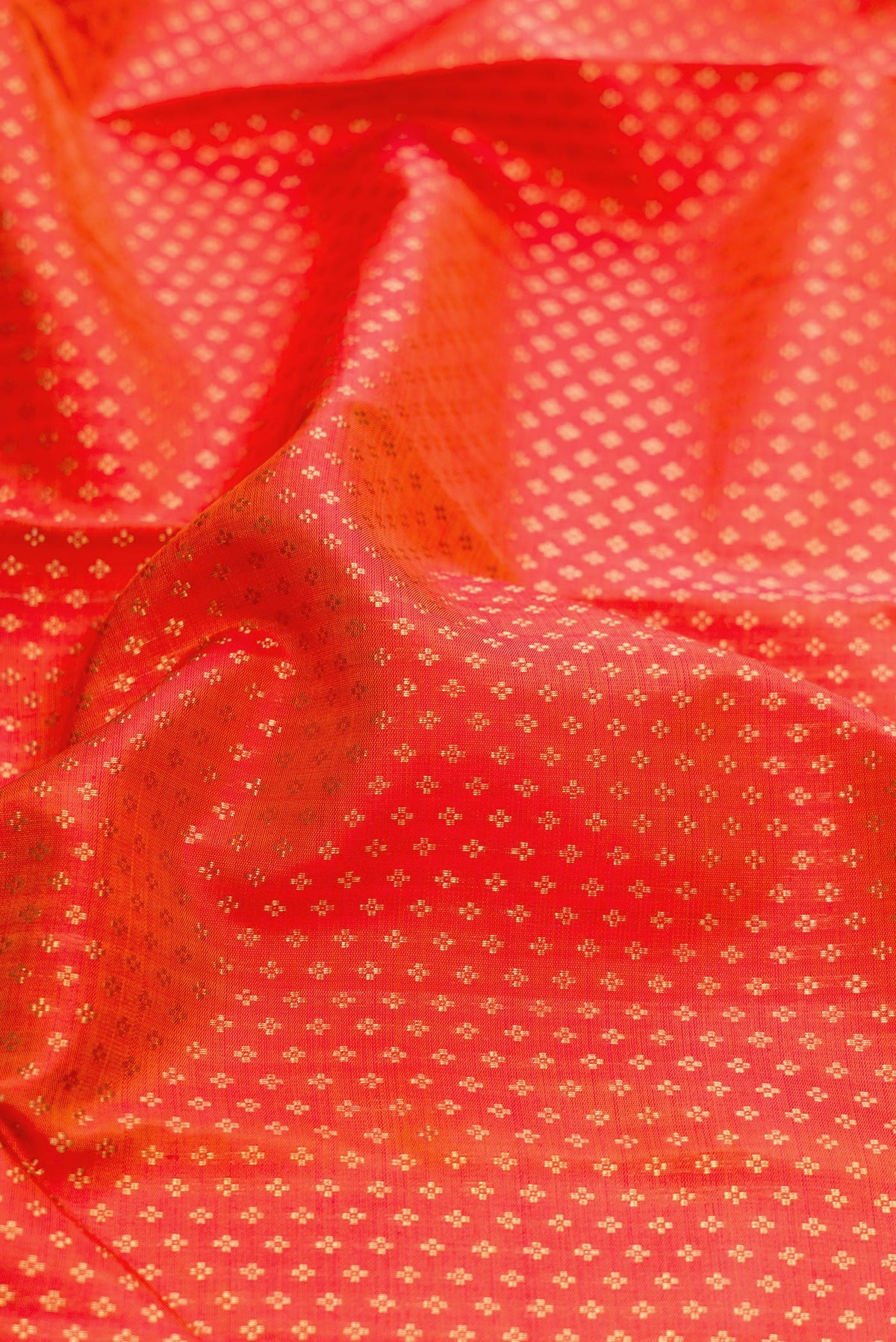 Close up of Pure Silk Pure Zari Orange Dual Tone Kanjivaram Saree with Zari Brocade on the body and Zari Border.  displaying folds