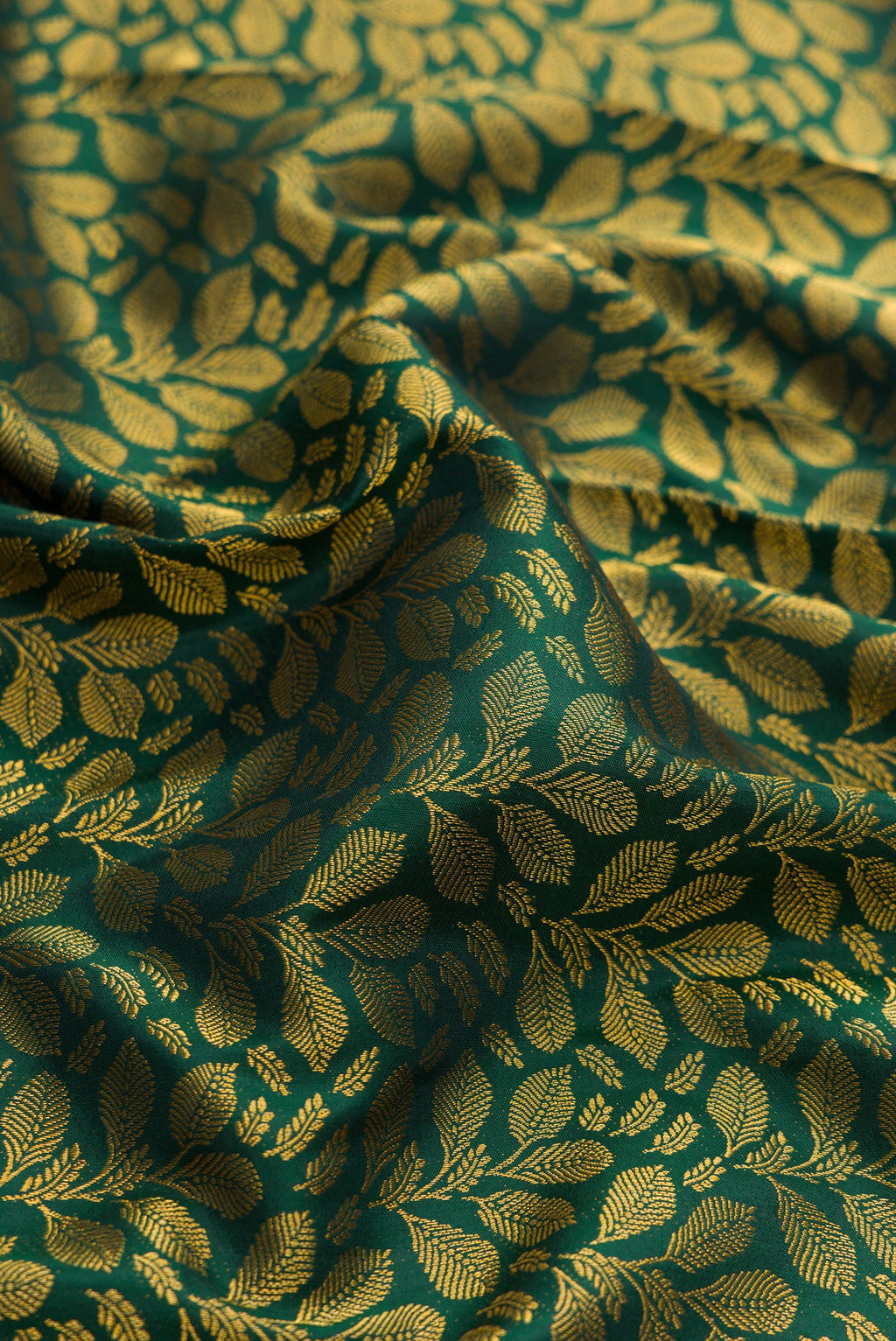 Close up of Green Dual Tone Kanjivaram Silk Saree with Zari Brocade on the body and Zari Border.  displaying folds
