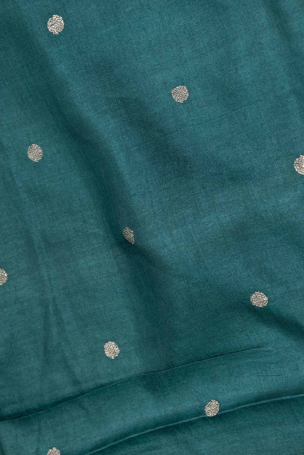 Close up of Peacock Blue Dual Tone Tussar Saree with Zari Butta on the body and Embroidery Border displaying folds
